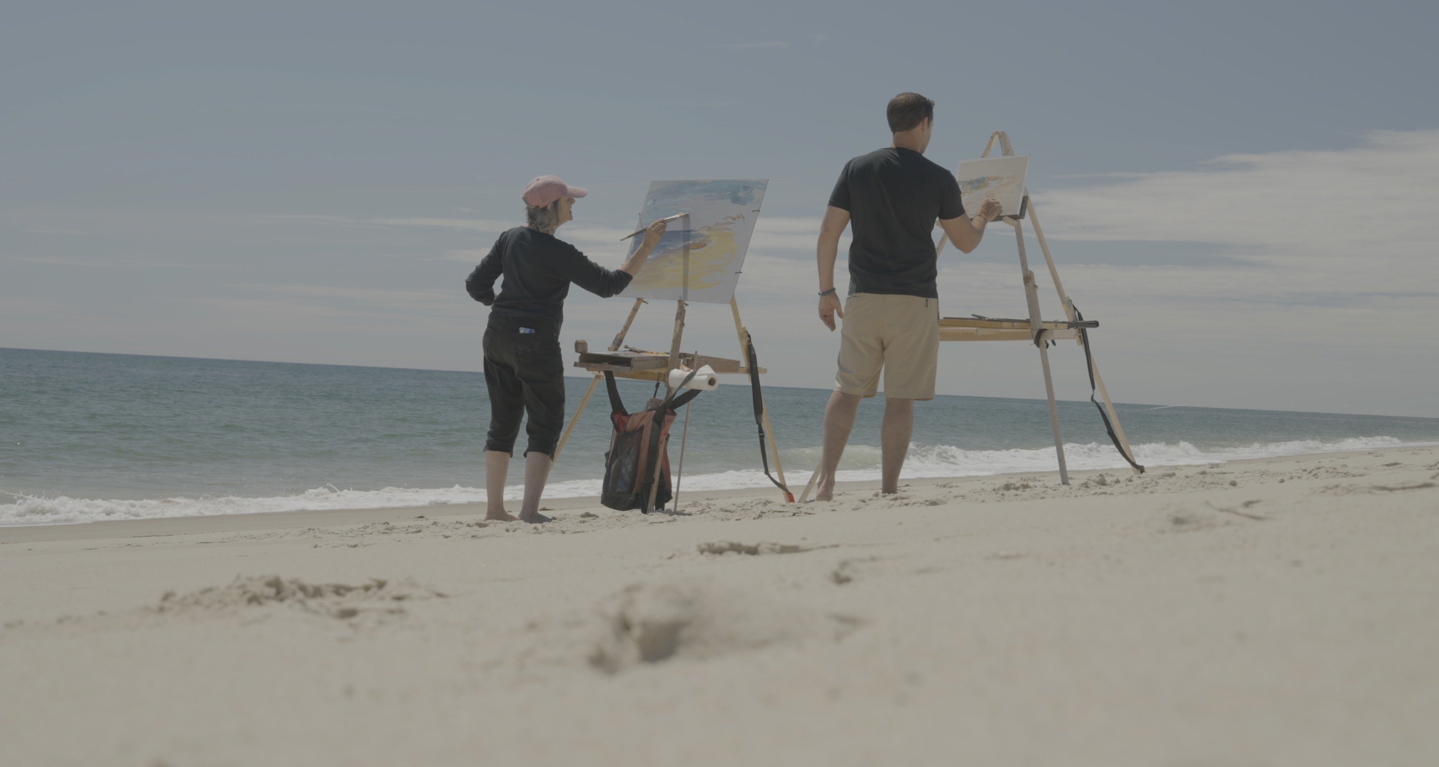 Two professional artists painting on the beach using Nadeau Easel with very different sized canvases.